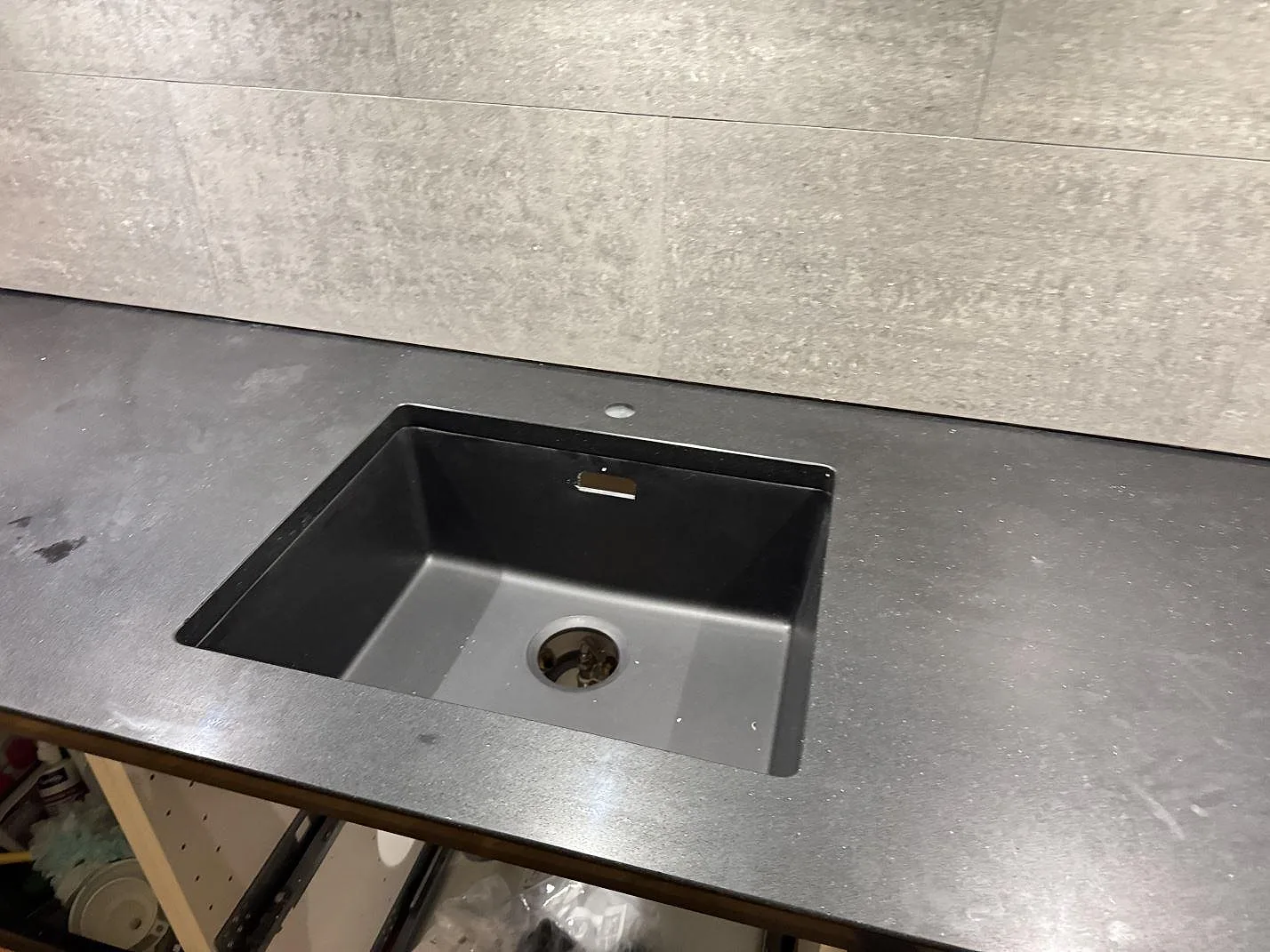Köksbänkskiva i mörk Silestone Night Tebas, polerad, med underlimmad mörk komposithon i ett kök i Trelleborg.