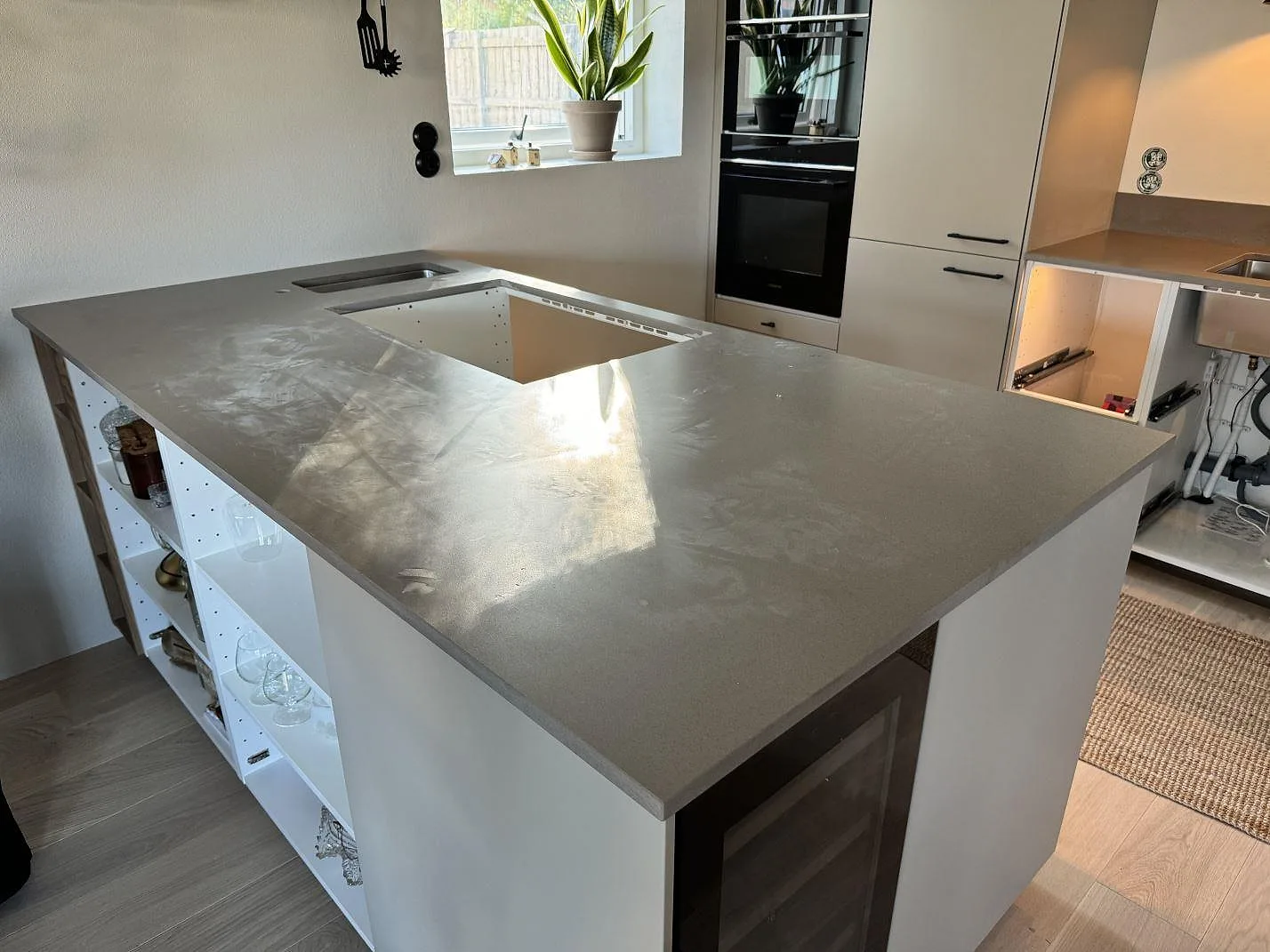 Köksö och väggbänk i grå Silestone Noka, mocka-finish, under montering i ett kök i Sölvesborg.