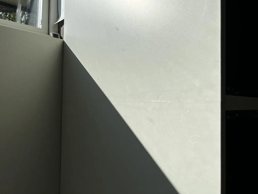 Närbild på matt greige Silestone Nolita med mjuk ådring och uppvikt stänkkant i ett kök i Eslöv.