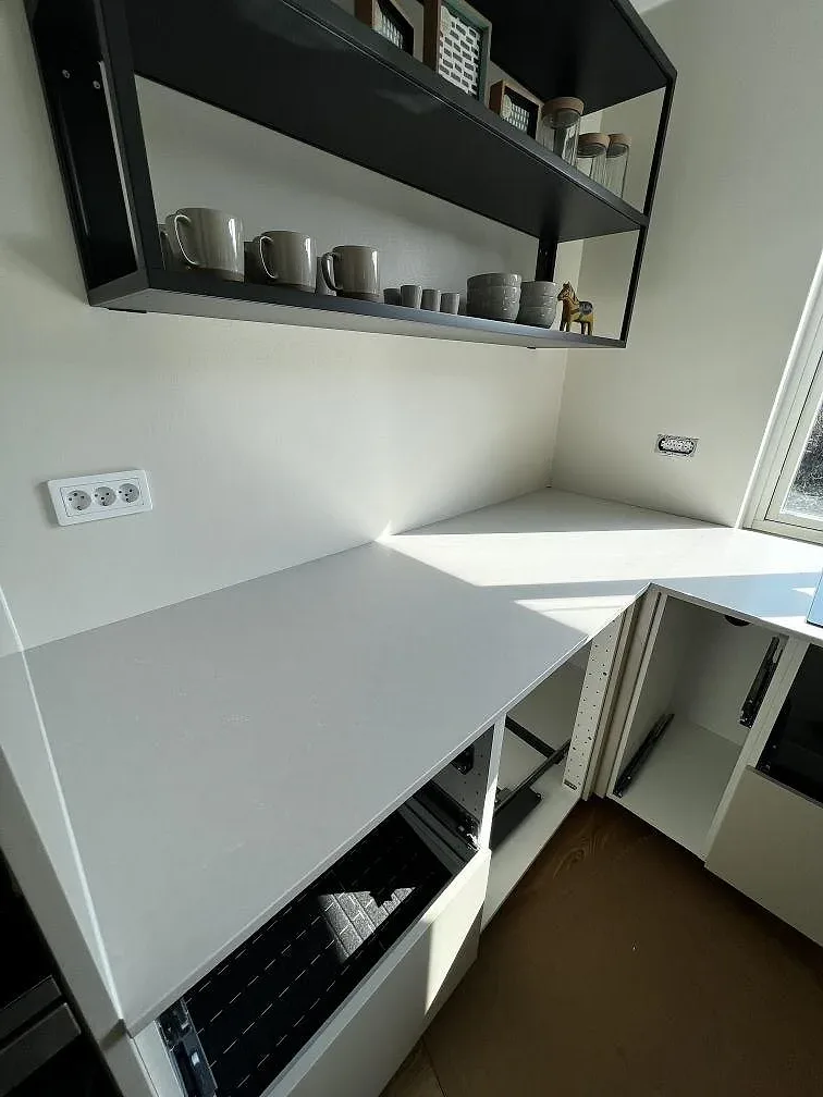 Bänkskiva i greige Silestone Nolita längs en fönstervägg i ett kök i Eslöv.