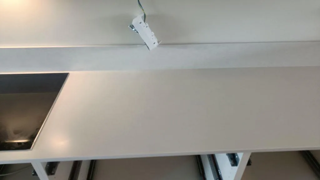 Lång bänkskivedel i Silestone Nolita, Mocka, med låg stänkkant och synlig hällyta i kök i Limhamn.