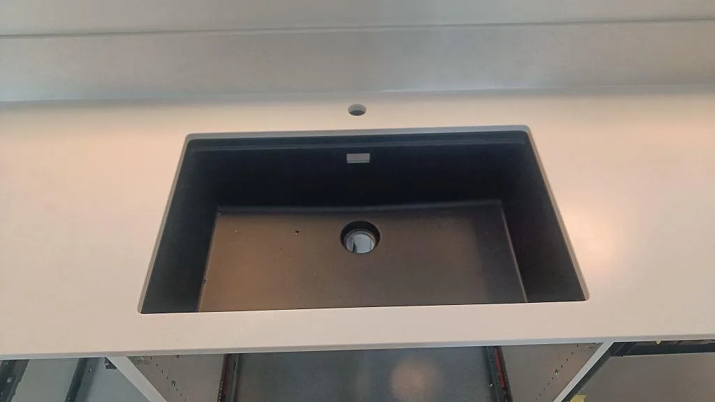 Svart underlimmad diskho monterad under en ljus Silestone Nolita bänkskiva med matt Mocka-yta i Limhamn.