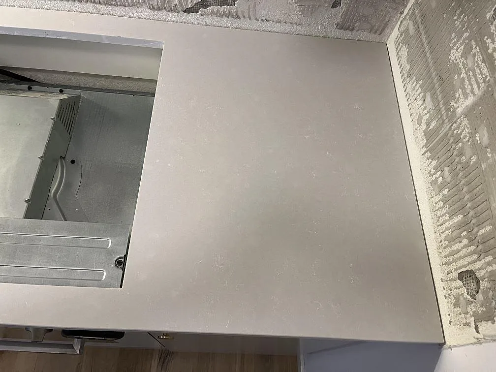 Matt Silestone Nolita bänkskiva med urtag för häll och synlig ugnsnisch under monteringen i ett kök i Malmö.