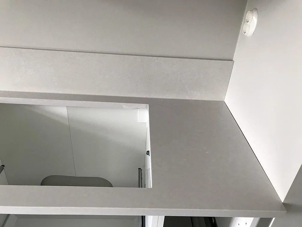Installerad köksbänkskiva i matt Silestone Nolita med vägguttag och stänkkant i ett kök i Malmö.