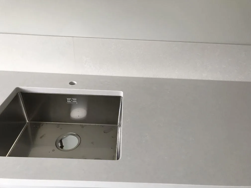 Underlimmad rostfri diskho i en köksbänkskiva av cremebeige Silestone Nolita med matt yta i Malmö.