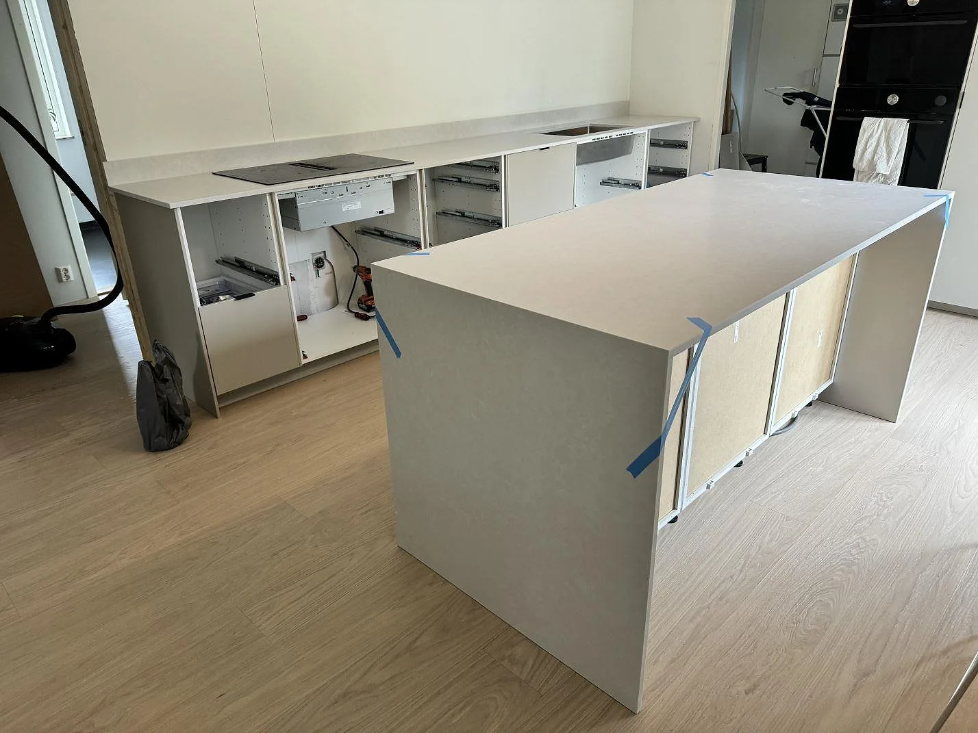 Stor köksö och köksbänkskiva i vit Silestone Nolita, matt Mocka-yta, under montering i ett kök i Nättraby.