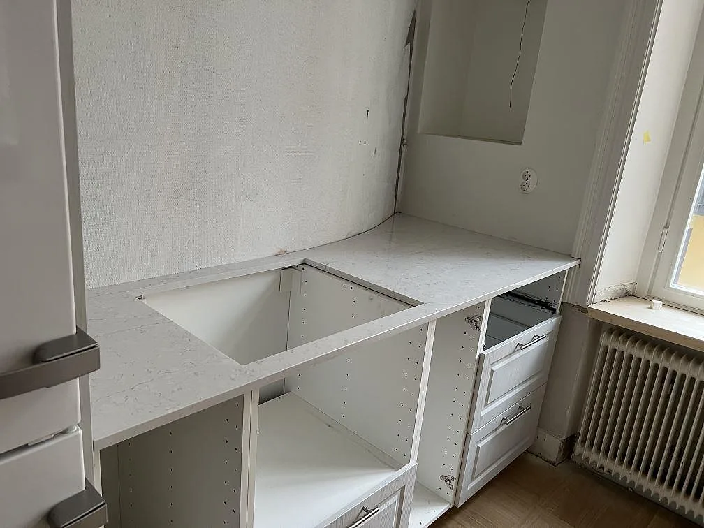 Rak köksbänkskiva i polerad Silestone Pearl Jasmine, ljus kvartskomposit, med stor rektangulär utskärning i ett kök under montering i Stockholm.