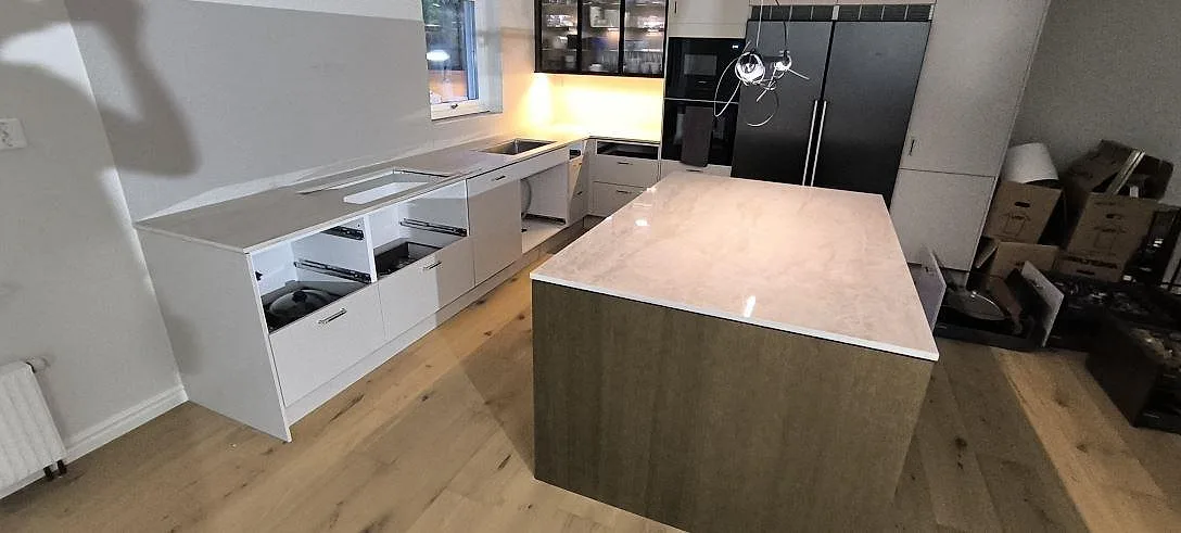 Köksö med ljus Silestone Persian White i polerad kvartskomposit, monterad på träbas i ett kök i Borlänge.