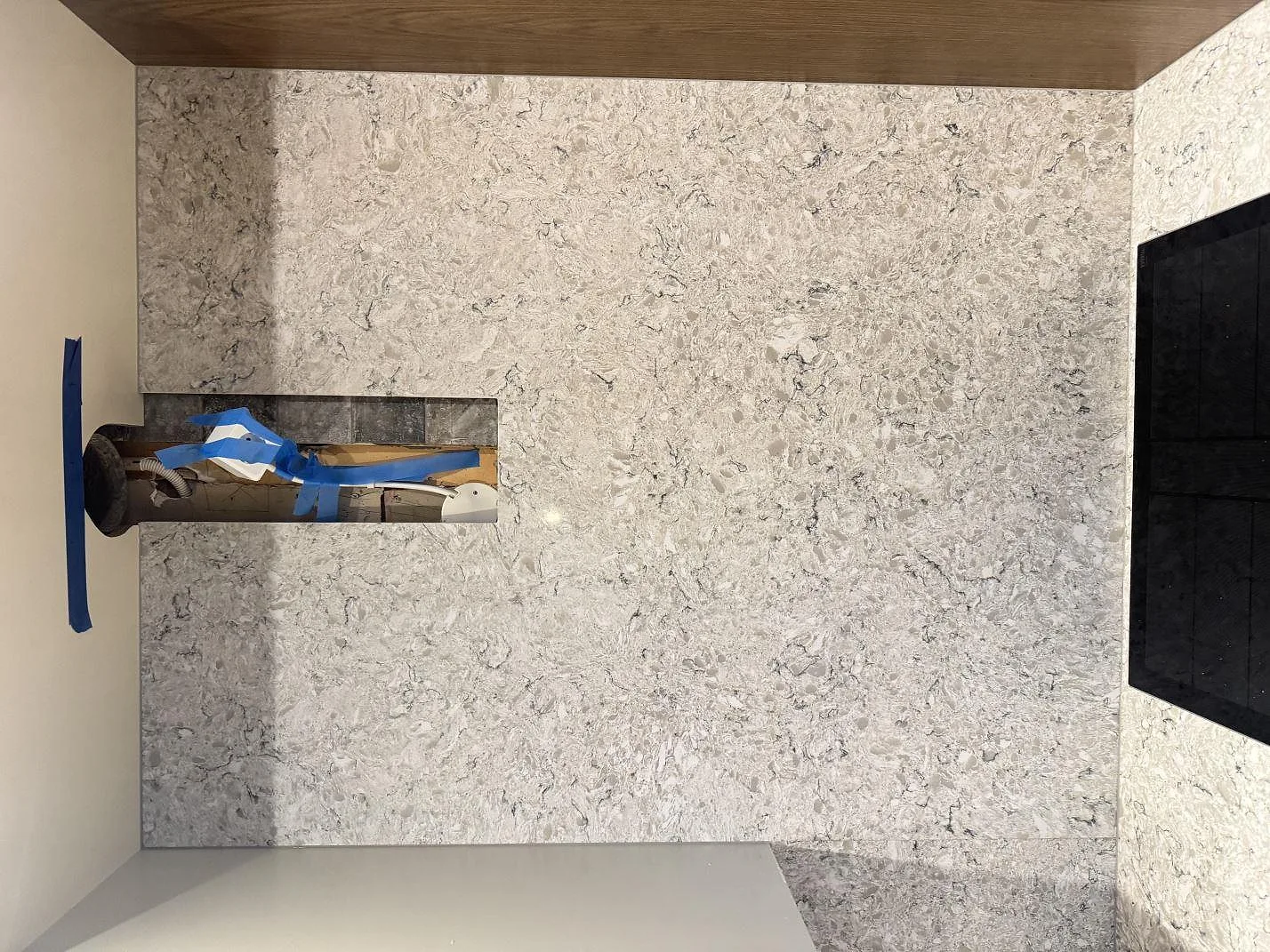 Heltäckande stänkvägg i Silestone Pietra med nisch bakom köksbänken i ett kök i Hällingsjö.
