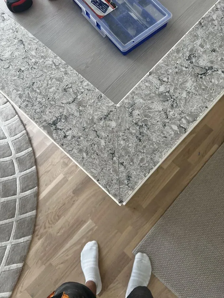 Topvy av gråvit Silestone Pietra bänkskiva i polerad komposit med mönstrad teckning och hörnskarv i Malmö.