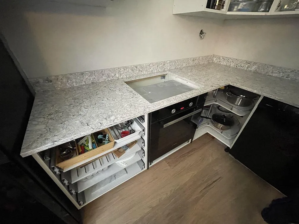 Polerad köksbänkskiva i Silestone Pietra med granitlik spräcklighet och urtag för häll ovanför inbyggnadsugn i ett kök i Stockholm.