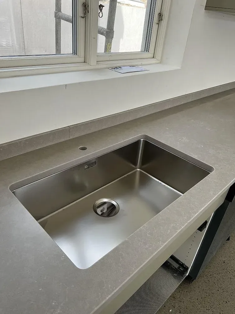 Köksbänkskiva i beige Silestone Poblenou med matt yta och underlimmad rostfri diskho i ett kök under montering i Glumslöv.