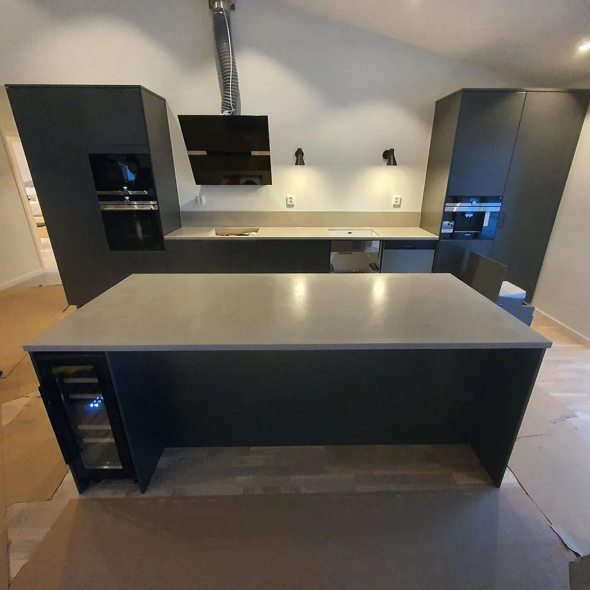 Köksbänkskiva och köksö i grå Silestone Poblenou, Mocka finish, med låg stänkkant i ett kök i Hedermora.