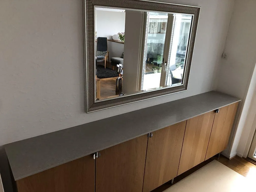 Köksbänkskiva i ljust greige Silestone Poblenou, matt kvartskomposit, på ett skåpparti med ekluckor i ett kök i Malmö.