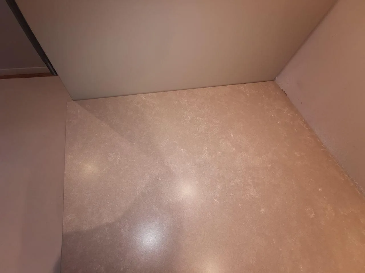 Köksö i matt beige Silestone Poblenou Mocka med urtag för häll i ett kök i Ystad.
