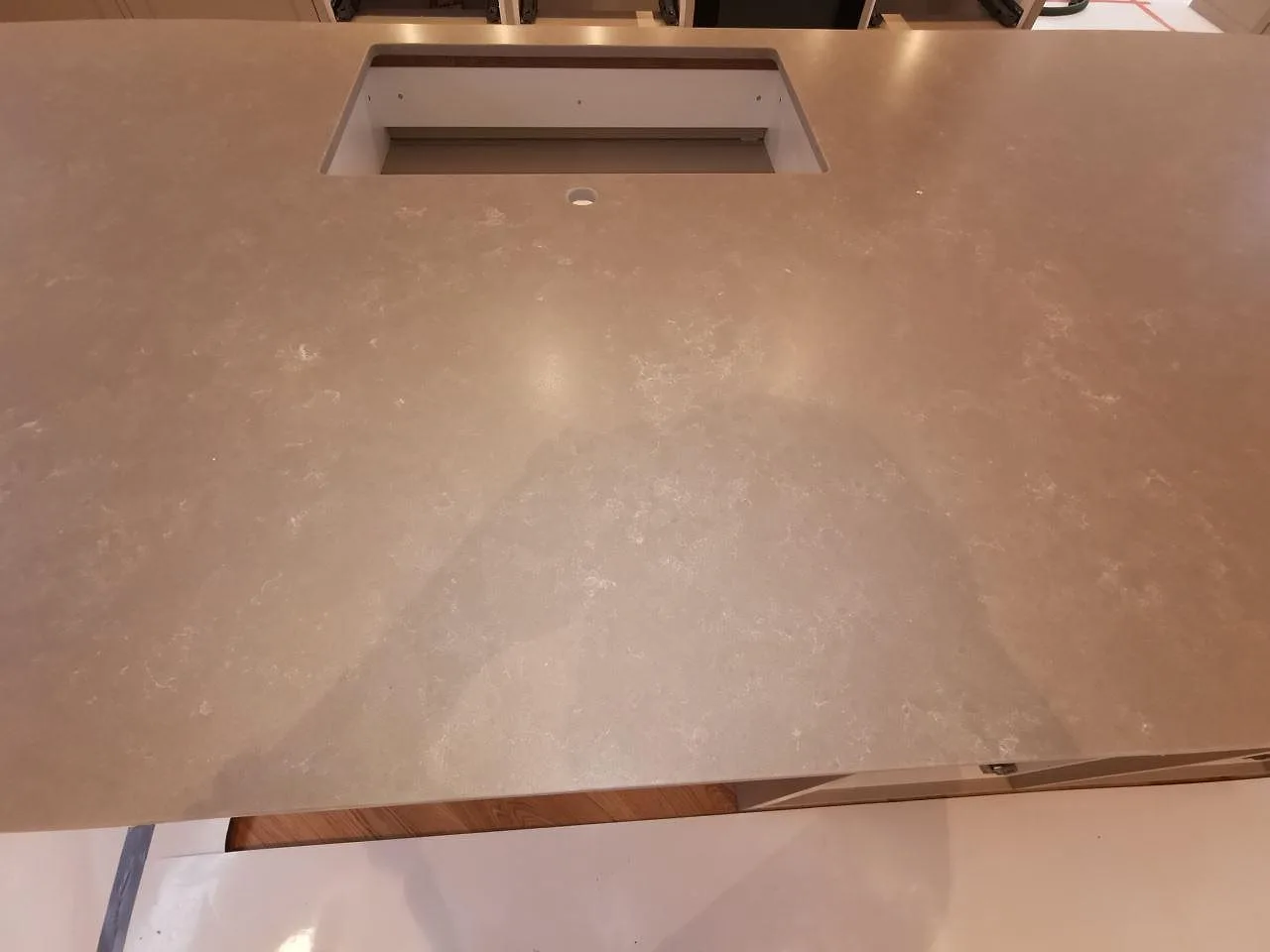 Installerad köksö i Silestone Poblenou Mocka mot köksinredning med inbyggd ugn i ett kök i Ystad.