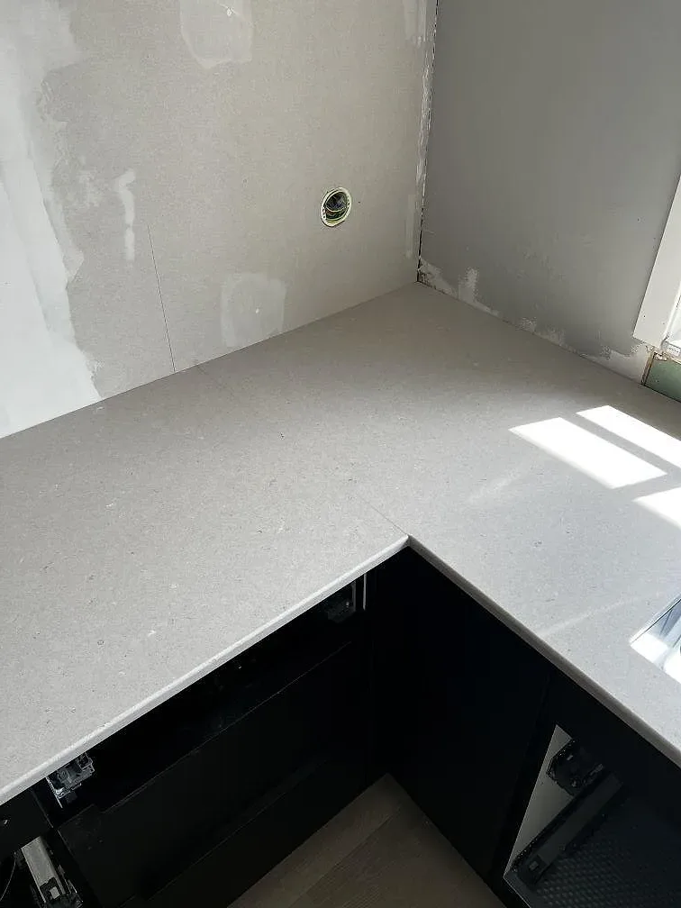 Ljus kompositbänkskiva i Silestone Royal Reef, Mocka, med väggnära avslut och solljus i Ängelholm.