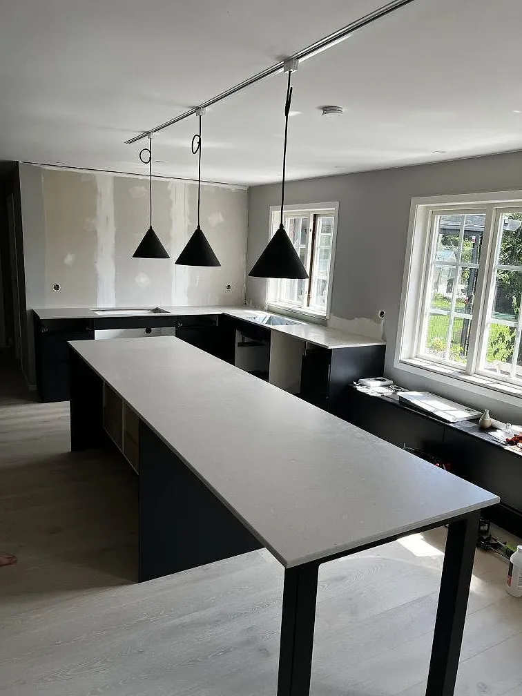 Köksbänkskiva i ljus Silestone Royal Reef, Mocka, som köksö och bänk mot svarta stommar i Ängelholm.