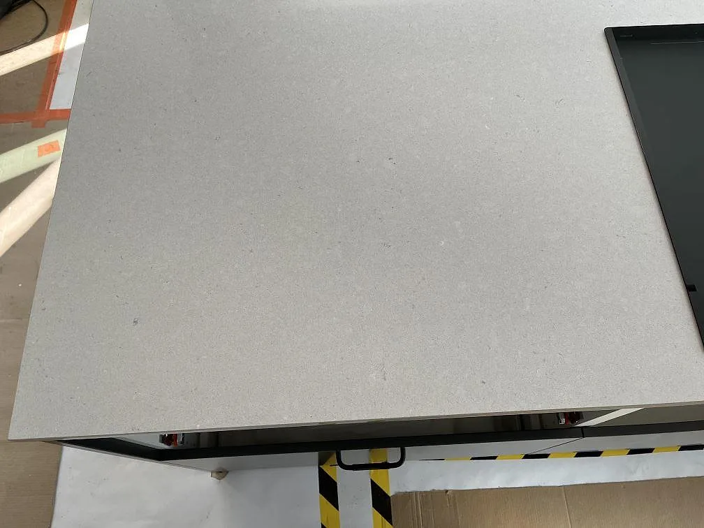 Bred arbetsyta i Silestone Royal Reef, polerad beigegrå komposit, intill svart häll i Bergkvara.
