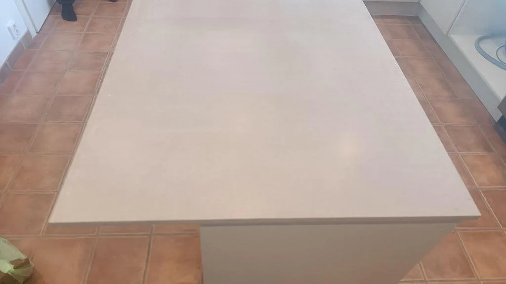 Topvy över stor köksö i matt Silestone Royal Reef med ljus beige komposityta och terrakottafärgat golv i Bjärred.