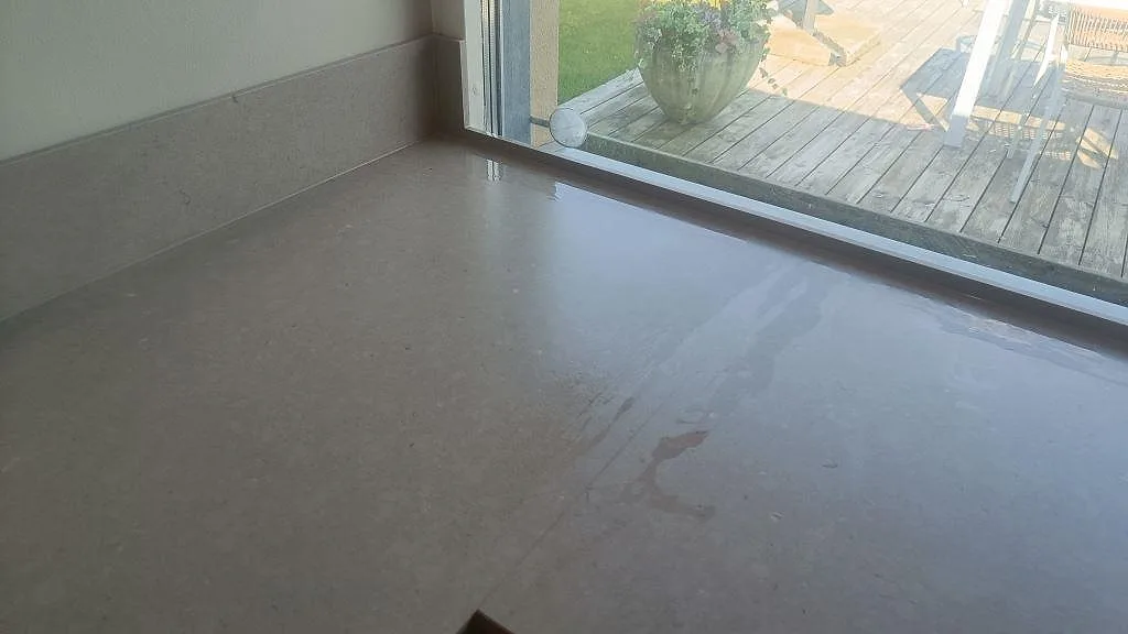 Närbild på matt Silestone Royal Reef med ljus ådring, låg stänkkant och trädgårdsfönster i Bjärred.