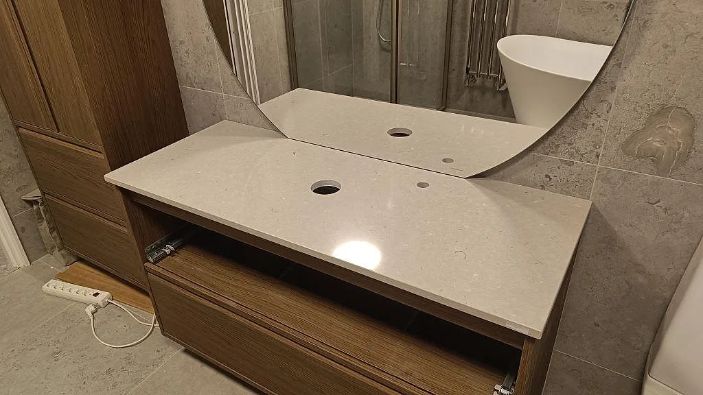 Badrumskommod med polerad Silestone Royal Reef bänkskiva i kvartskomposit och förborrade hål för tvättställ i Bjärred.