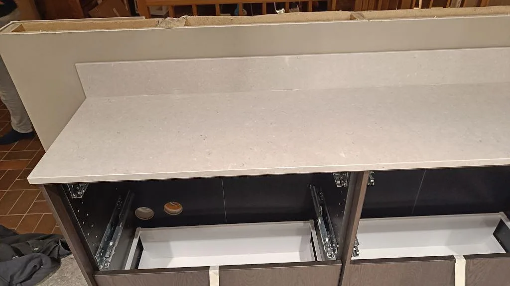Detalj av Silestone Royal Reef bänkskiva i kvartskomposit med uppvikt stänkkant och blandad finish under montering i Bjärred.