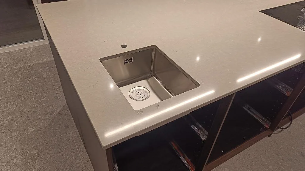 Närbild av underlimmad rostfri diskho i en polerad Silestone Royal Reef köksbänkskiva i kvartskomposit i Bjärred.