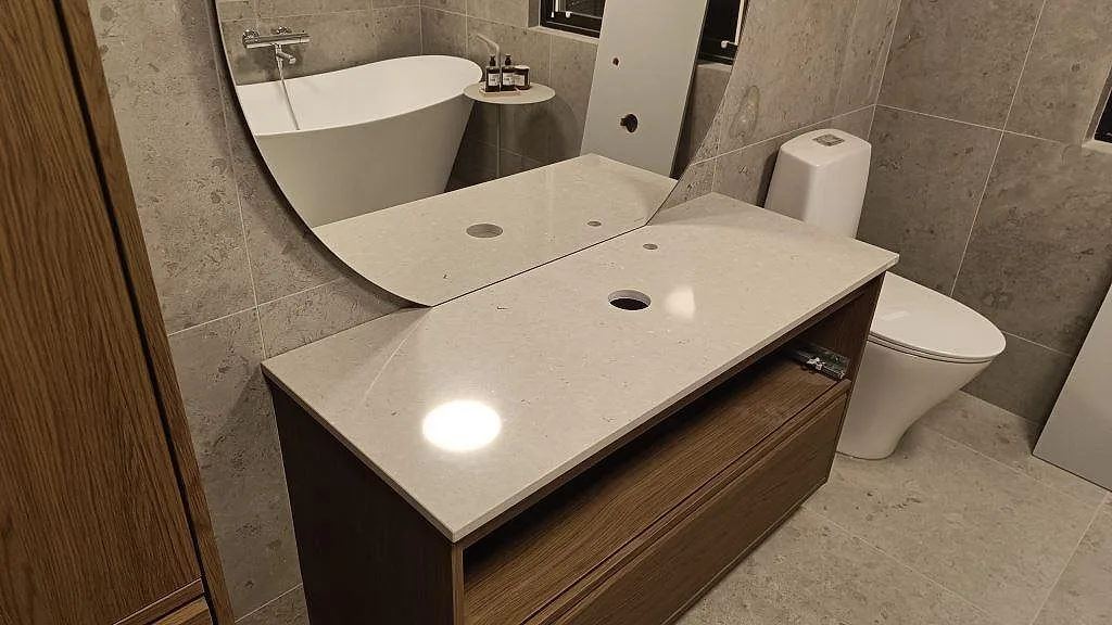 Badrumsskiva i Silestone Royal Reef, polerad kvartskomposit, med hål för tvättställ och blandare på kommod i Bjärred.