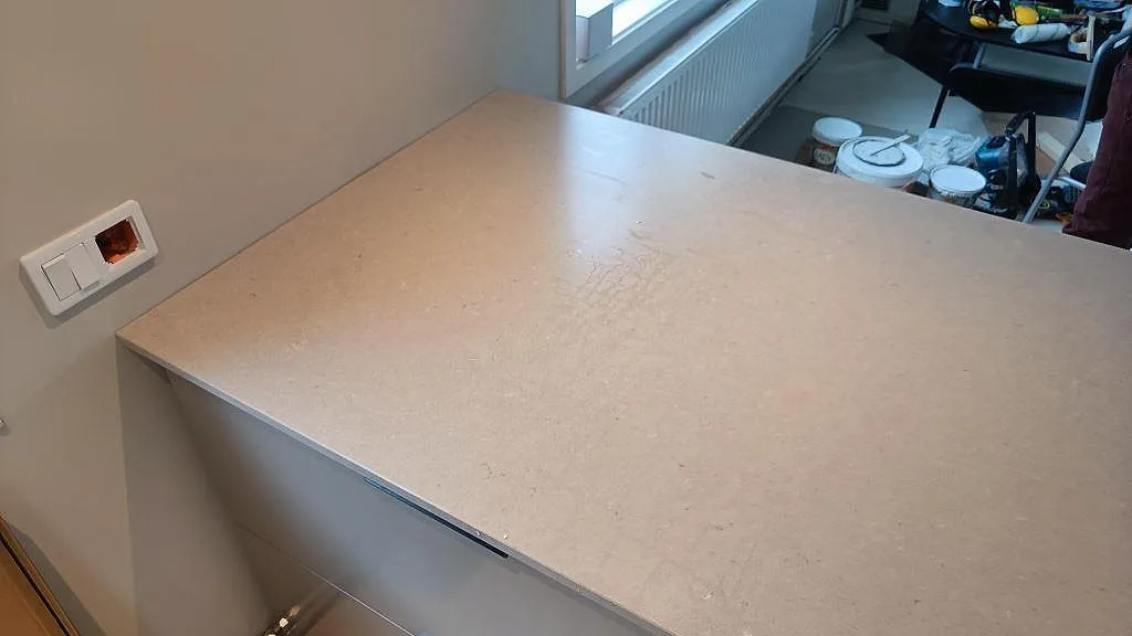 Hörn av en matt beige Silestone Royal Reef-bänkskiva mot vägg i ett kök i Fagerfjäll.
