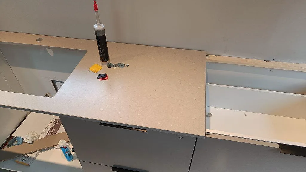 Bänkskiva i matt beige Silestone Royal Reef med urtag för diskho i ett kök under montering i Fagerfjäll.