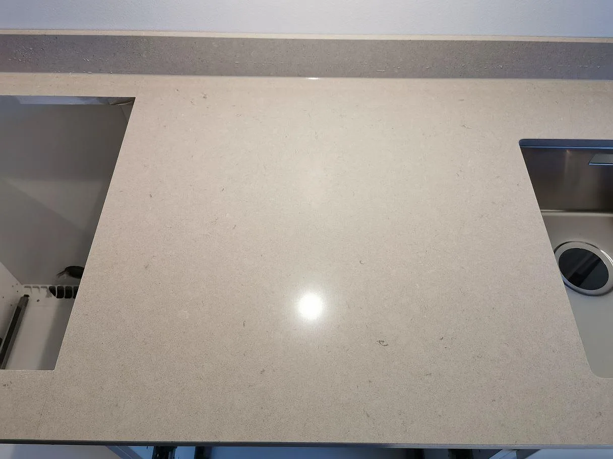 Polerad Silestone Royal Reef köksbänkskiva med urtagning för spishäll och underlimmad diskho samt låg stänkkant i ett kök i Göteborg.