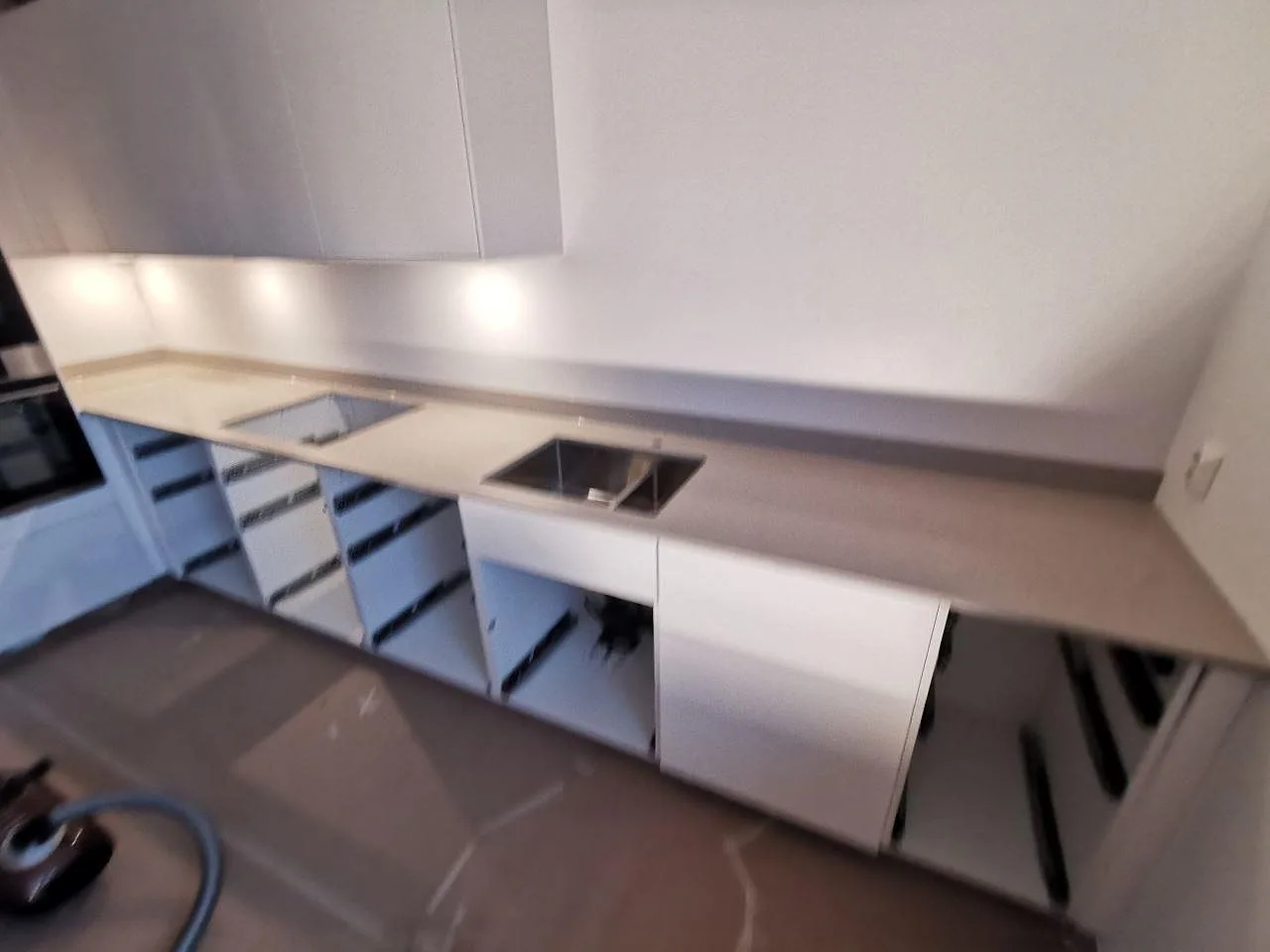 Krämvit Silestone Royal Reef köksbänkskiva monterad längs köksväggen med underlimmad diskho och urtagning för spishäll i Göteborg.