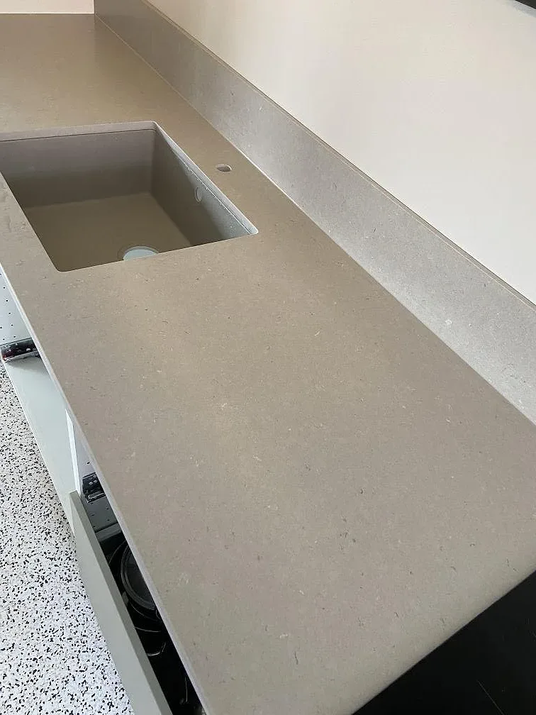 Närbild på en undermonterad diskho i en matt gråbeige Silestone Royal Reef-köksbänkskiva i Göteborg.