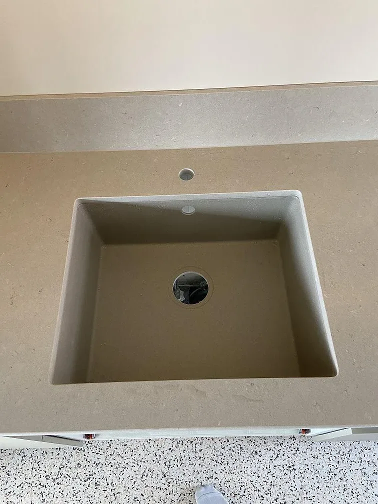 Underlimmad diskho i komposit med borrade blandarhål i en matt Silestone Royal Reef-bänkskiva i ett kök i Göteborg.