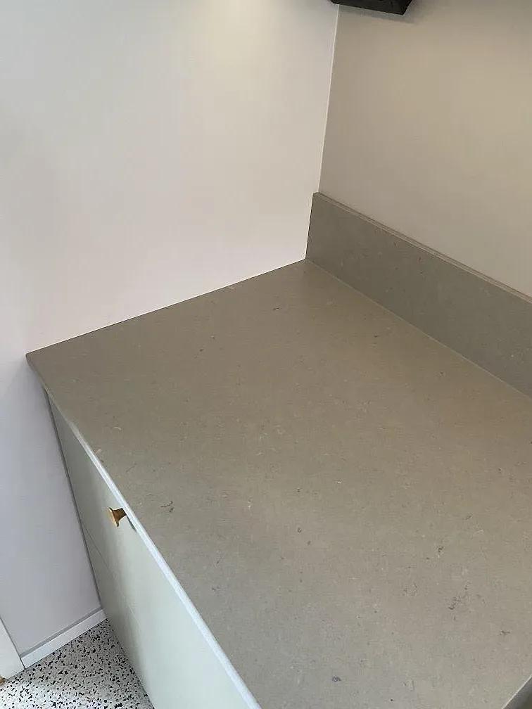 Köksbänkskiva i Silestone Royal Reef i matt Mocka-yta i ett kök i Göteborg, med vita luckor, mässingsfärgad knopp och ljust terrazzogolv.