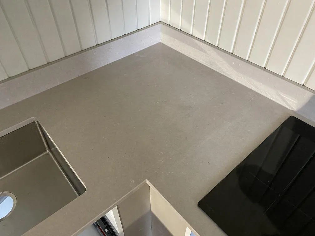 L-formad köksbänkskiva i polerad Silestone Royal Reef i Göteborg, med hörnpassning, underlimmad rostfri diskho och svart häll.