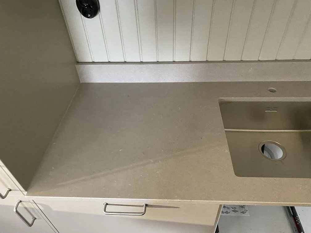 Köksbänkskiva i polerad Silestone Royal Reef längs vit pärlspont i Göteborg, med rostfri diskho och rundat kranhål.