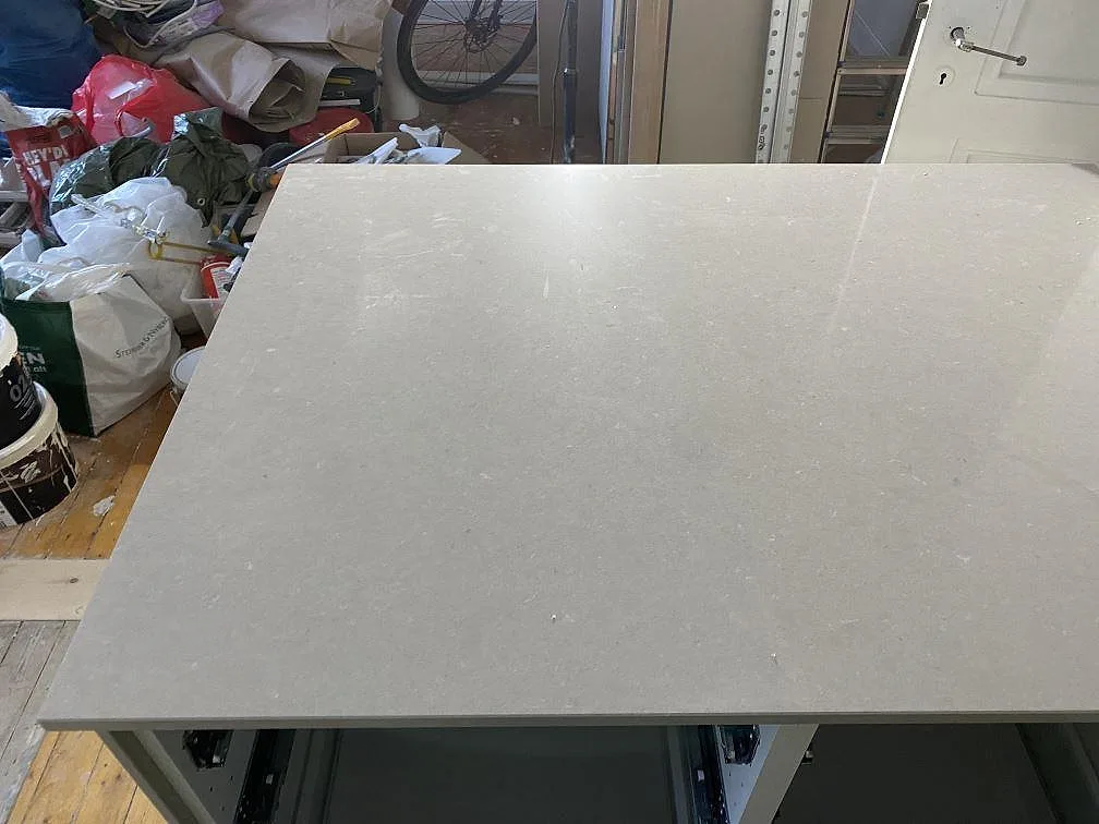 Ljus gråbeige köksbänkskiva i polerad Silestone Royal Reef monterad över öppna köksstommar i Göteborg.