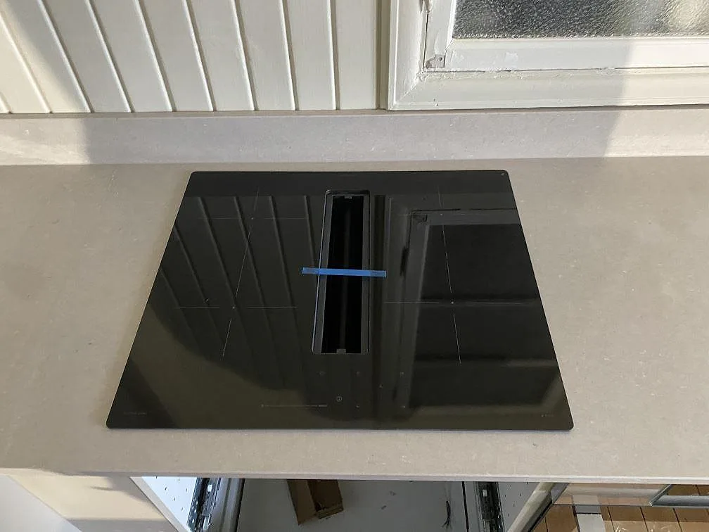 Svart häll i köksbänkskiva av polerad Silestone Royal Reef med ljus gråbeige yta i Göteborg.