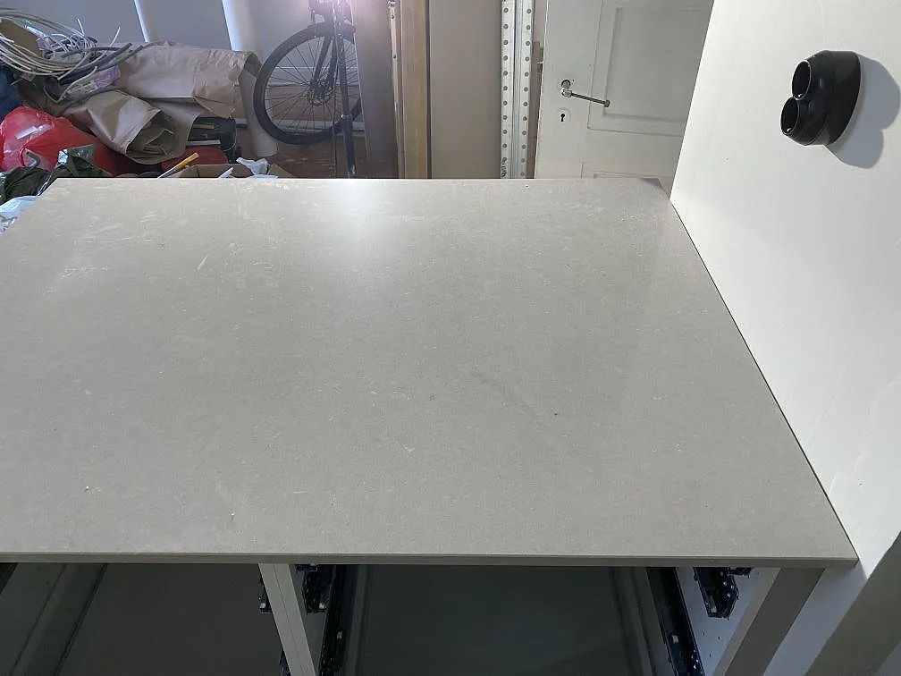 Rak bänkyta i polerad Silestone Royal Reef över köksstommar i Göteborg, med synlig stenkant och vägguttag ovanför.