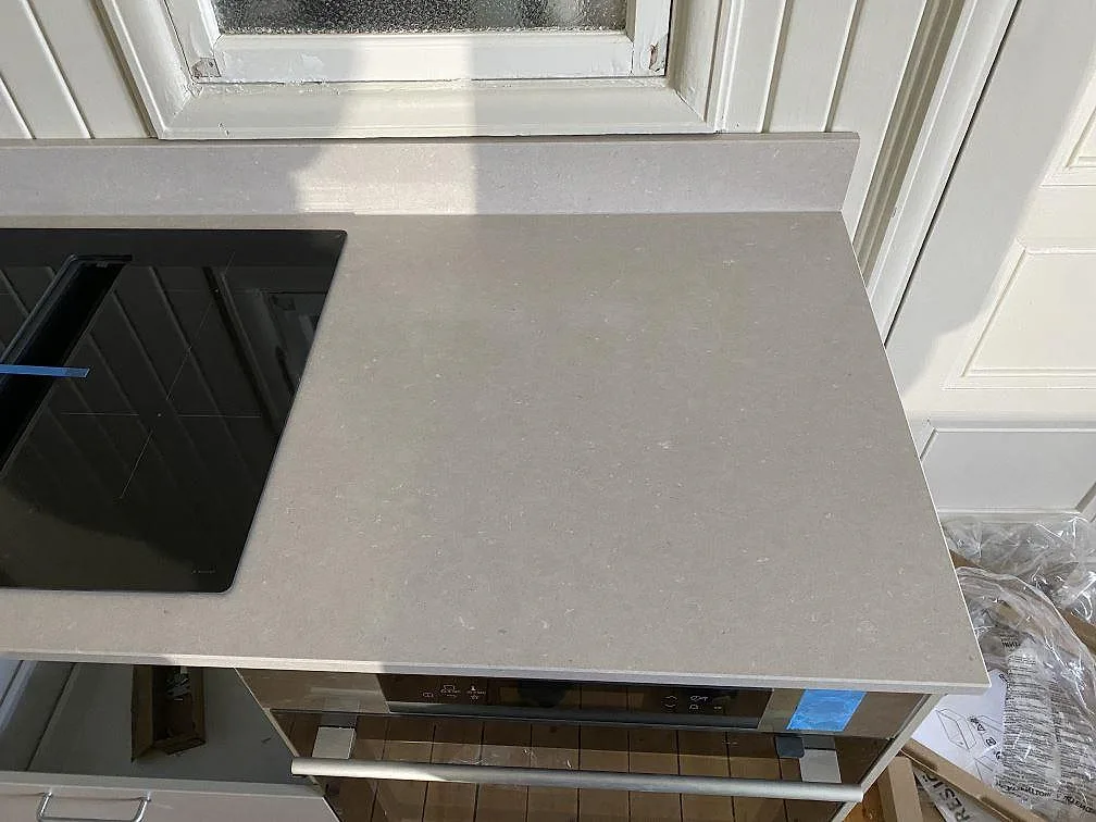 Polerad Silestone Royal Reef som köksbänkskiva vid fönster i Göteborg, med svart häll och monterad stänkkant.