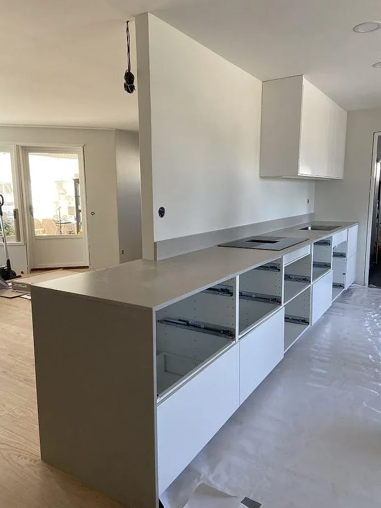 Köksö och bänkskiva i matt Silestone Royal Reef med öppna stommar i ett kök under montering i Hässleholm.