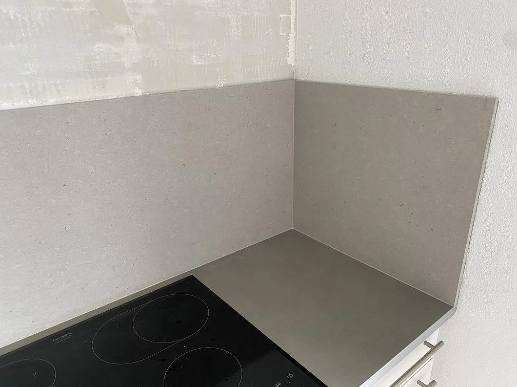 Matt Silestone Royal Reef som bänkskiva och stänkskydd vid svart induktionshäll i ett kök i Höllviken.