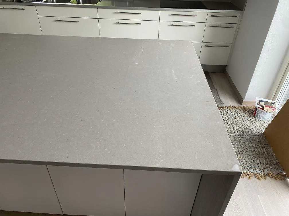 Ovansida på köksö i matt Silestone Royal Reef, ljusgrå komposit med diskret mönster, i Höllviken.