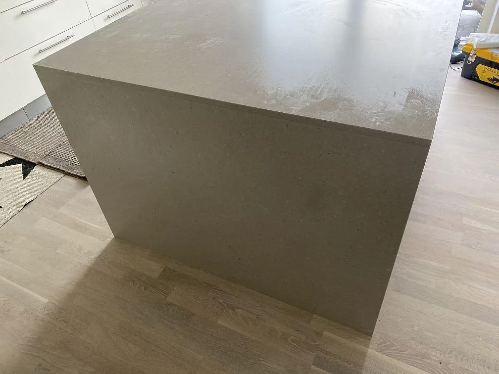 Sidovy av köksö i matt Silestone Royal Reef med neddragen kompositgavel och ljust trägolv i Höllviken.