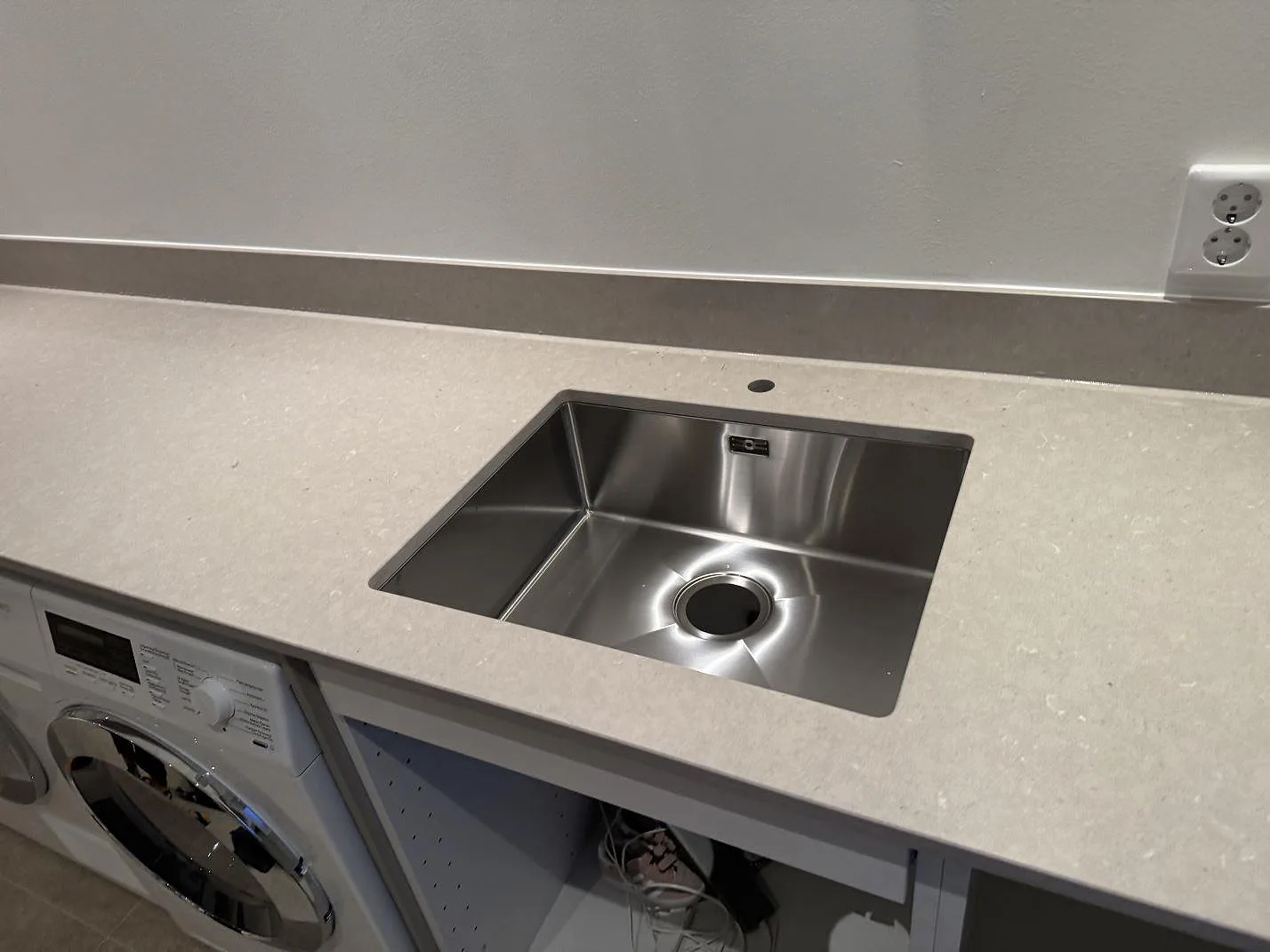Polerad Silestone Royal Reef som bänkskiva med rostfri diskho, kranhål och låg stänkkant i Höllviken.