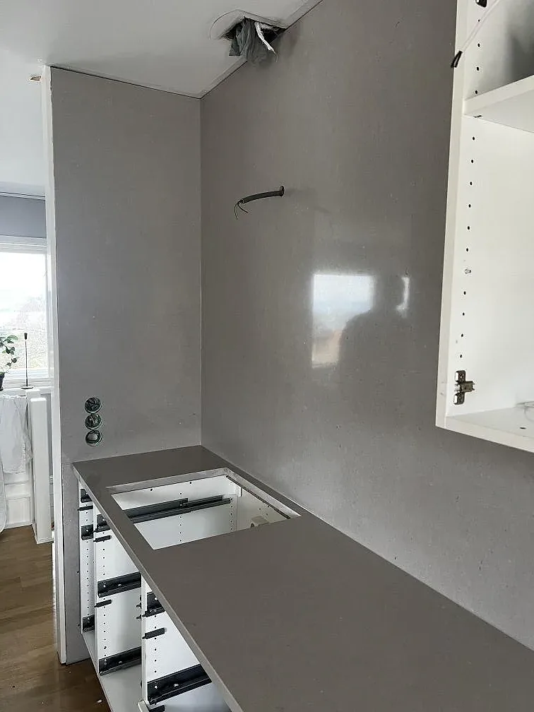 Köksbänkskiva i Silestone Royal Reef, polerad kvartskomposit med urtag för diskho, längs fönstret i ett kök under montering i Huskvarna.