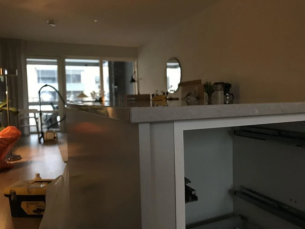 Sidovy av 20 mm polerad Silestone Royal Reef på vit köksö under montering i Jönköping.