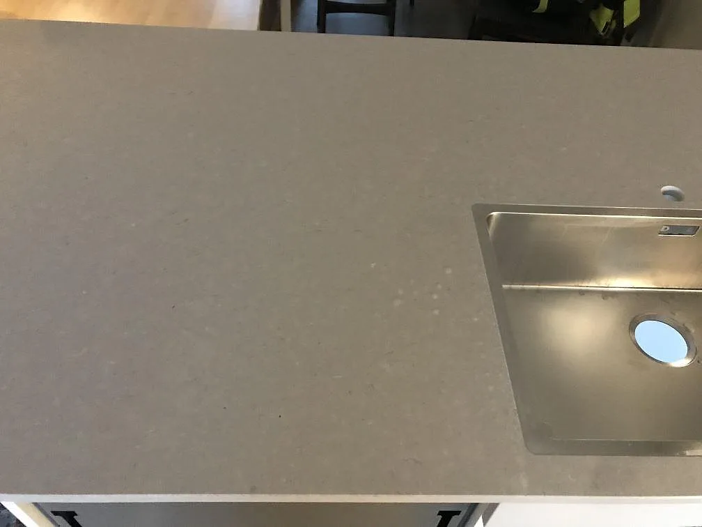 Underlimmad rostfri diskho i bänkskiva av Silestone Royal Reef i varmbeige kvartskomposit i ett kök i Jönköping.